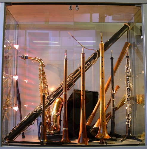 Immagine con strumenti, vetrina, musica, sassofono, vetro, flauto, clarinetto, oboe, tromba, saxofono, faretti, musicali, riflessi, negozio, riflesso