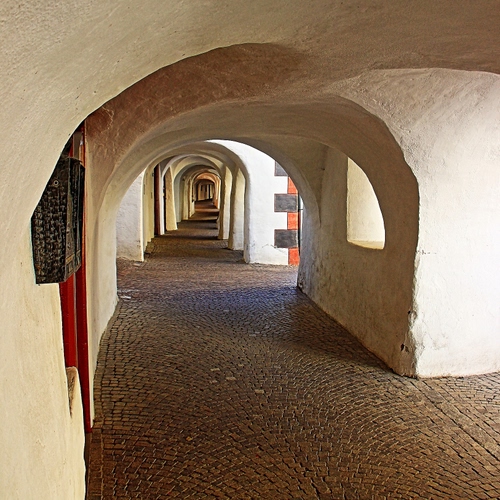 Immagine con archi, bianco, portici, portico, prospettiva, pilastri, arco, porta, porfido, rosso, selciato