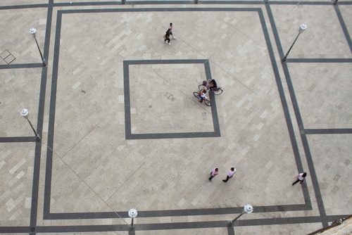 Immagine con lampioni, piazza, quadrati, persone, biciclette, geometrie, passanti