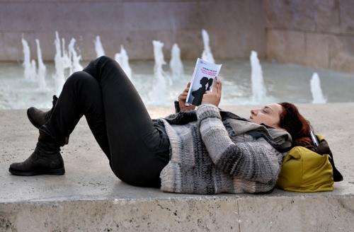 Immagine con fontana, libro, donna, acqua, leggere, borsa, giallo, nero, maglione, sdraiata, marmo, lettrice, zampilli, gambe