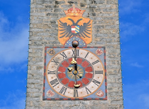 Immagine con orologio, stemma, lancette, torre, numeri, aquila, cielo