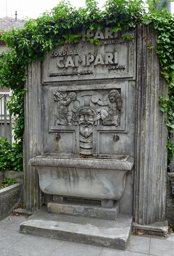 Immagine con fontana, rubinetti, edera, verde, vasca, foglie, marmo, colonne, pubblicità, monumento, campari, pianta