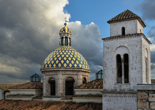 Immagine con cupola, nuvole, campanile, cielo, tetti, finestre, tetto, croce, archi, chiesa