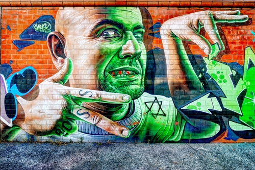 Immagine con verde, murales, mani, occhi, muro, dita, uomo, mattoni, naso, viso, murale, stella, bocca, volto, tre, denti