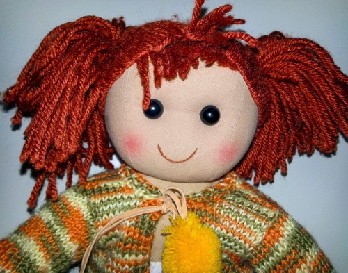 Immagine con capelli, bambola, giallo, pezza, lana, occhi, rosso, verde, bocca, giocattolo, maglione, rossi, maglia, stoffa, arancione, righe