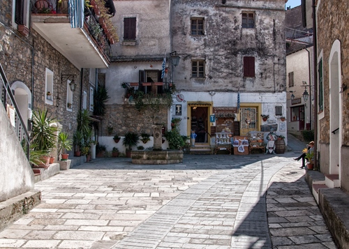 Immagine con balcone, finestre, negozio, piazza, fontana, piante, strada, borgo, piazzetta, vasi