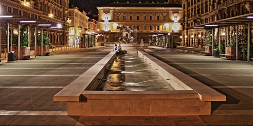 Immagine con fontana, piazza, acqua, palazzi, luci, notturno, zampilli, lampioni, notte, statue, vasca, finestre, persone, panchine, piante