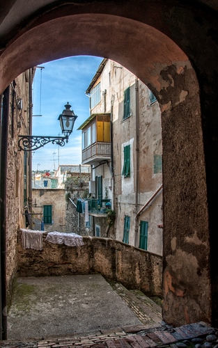 Immagine con lampione, arco, finestre, scorcio, balconi, balcone, borgo, case