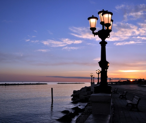 Immagine con mare, lampione, tramonto, panchine, lampioni, nuvole, lungomare, cielo, luci