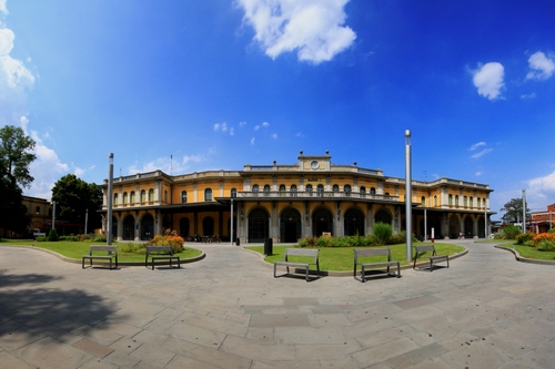 Immagine con panchine, aiuole, palazzo, lampioni, nuvole, piazza, archi, cielo, prato