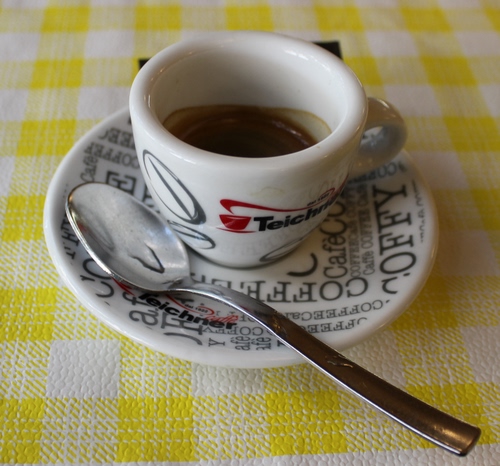 Immagine con caffè, cucchiaino, tovaglia, tazzina, piattino, scritte, giallo, bianco, quadretti, tazza, quadri