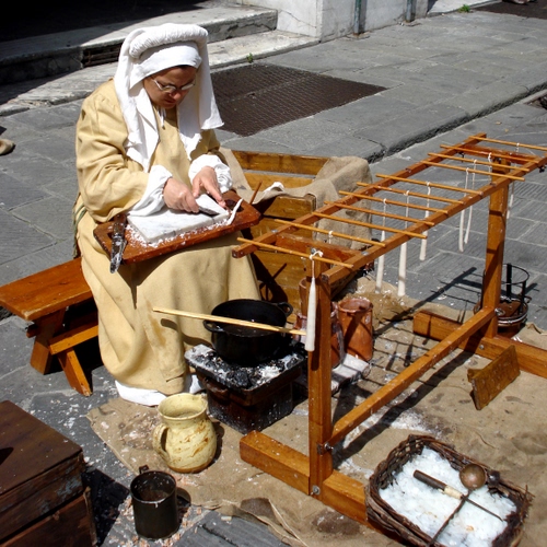 Immagine con donna, artigianato, candele, mani, panca, legno, vaso, brocca, cera, pentola, cappello, costume, artigiano