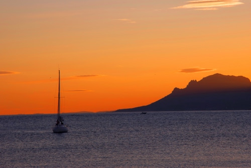 Immagine con mare, barca, tramonto, cielo, montagna, acqua, rosso, nuvole, arancione