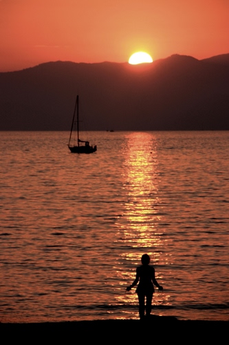 Immagine con tramonto, barca, mare, sole, controluce, lago, riflesso