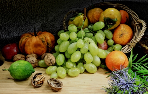 Immagine con frutta, uva, noci, arance, cesto, limone