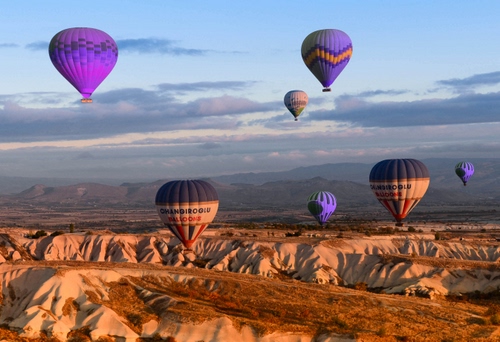 Immagine con mongolfiere, nuvole, cielo, montagne, viola, palloni, dune, roccia, sette