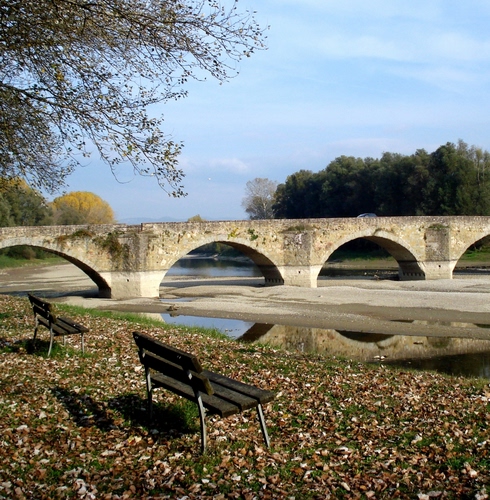 Immagine con ponte, panchine, fiume, foglie, archi, alberi, acqua, panchina, due