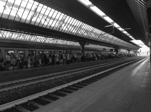 Immagine con stazione, binari, treno, bianconero, gente, prospettiva, binario, passeggeri, pensilina, attesa