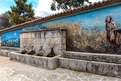 Immagine con murales, fontana, alberi, muro, acqua, lavatoio, fontane