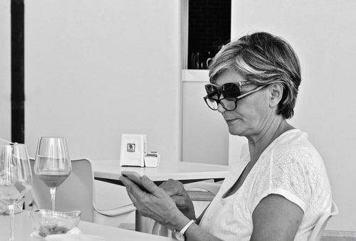 Immagine con occhiali, bicchieri, donna, cellulare, bianconero, mani, signora, tavolino