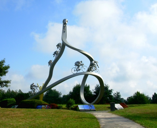 Immagine con monumento, ciclisti, prato, biciclette, cielo, curve, acciaio, nuvole, verde, aiuola