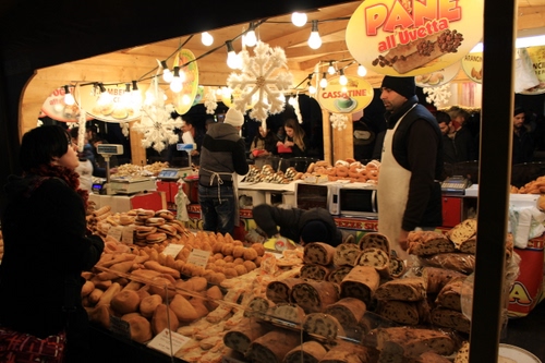 Immagine con dolci, mercato, pane, lampadine, luci, bancarella, venditori, persone, merce, grembiule, alimentari, vendita, banco, cartelli, fili