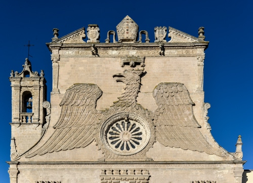 Immagine con campanile, rosone, aquila, chiesa, ali, croce, cielo, campana, facciata, tiara, blu, corona, azzurro, stemmi, frontone, mitra