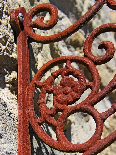 Immagine con ruggine, muro, ferro, fiore, cancello, rosso, spirali, vite, volute, marrone, cerchi