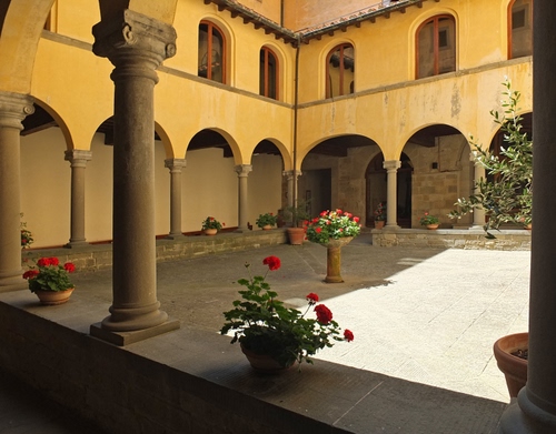 Immagine con colonne, finestre, vasi, fiori, chiostro, archi, capitelli, piante, cortile, gerani, ombra, ulivo, muretto, porticato, colonnato, vetri