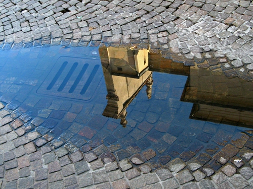 Immagine con acqua, riflesso, tombino, pozzanghera, cubetti, pavimento, chiesa, strada, porfido, grigio, pozza, sanpietrini