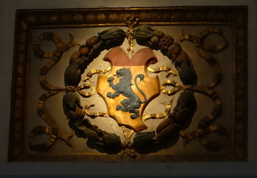 Immagine con stemma, leone, oro, cornice, giallo, nastri, rosso, corona, coda, frutta, ghirlanda, rettangolo, scudo, quadro