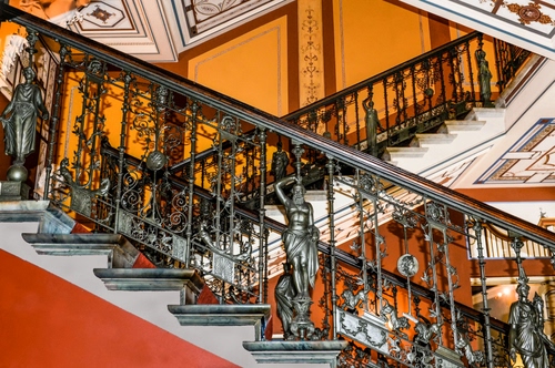Immagine con ringhiera, statue, scale, scala, scalini, ferro, gradini, corrimano, ringhiere, legno, decorazioni, marmo, geometrie, giallo, scalinata, arancione, rosso, diagonali