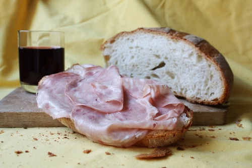 Immagine con bicchiere, vino, pane, mortadella, tagliere, cibo